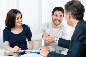 Happy couple seal a deal with their personal financial advisor a