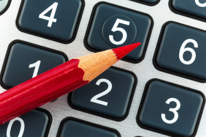 a red pen is on a calculator. save on costs, expenses and budget